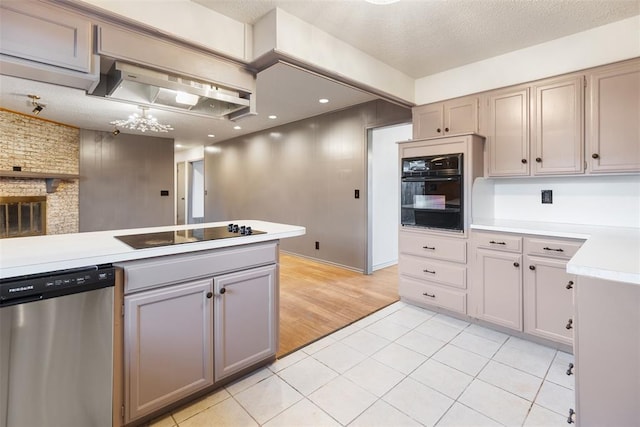 kitchen with a textured ceiling, black appliances, light tile patterned flooring, and light countertops