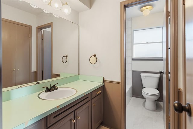 bathroom featuring wainscoting, vanity, and toilet