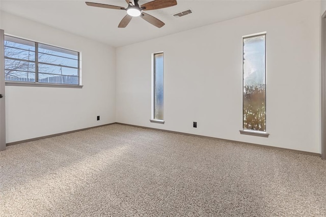 empty room with a ceiling fan, baseboards, visible vents, and carpet flooring