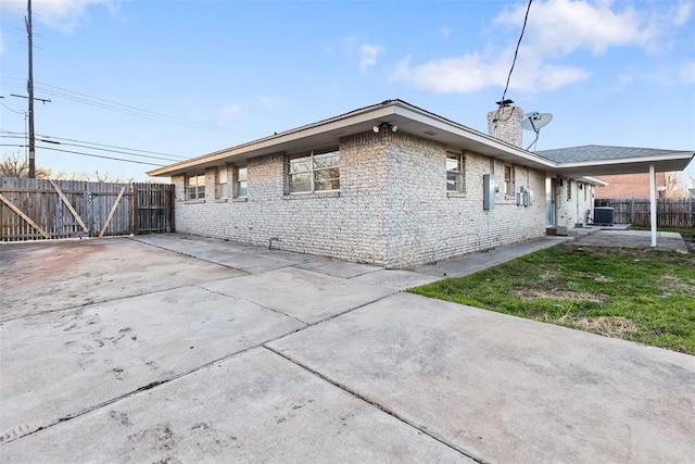 rear view of property featuring a chimney, fence, cooling unit, and a patio