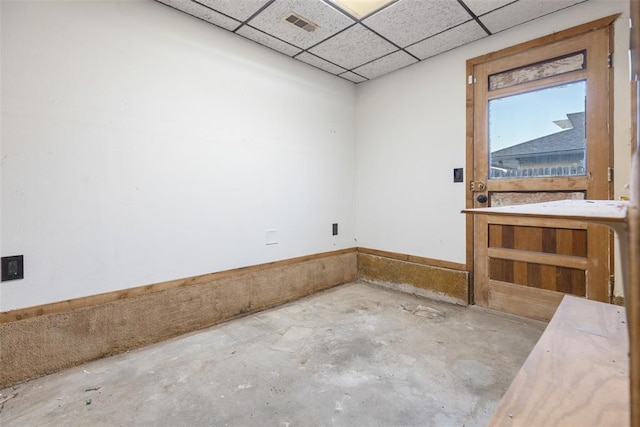 empty room with concrete flooring, a paneled ceiling, and visible vents