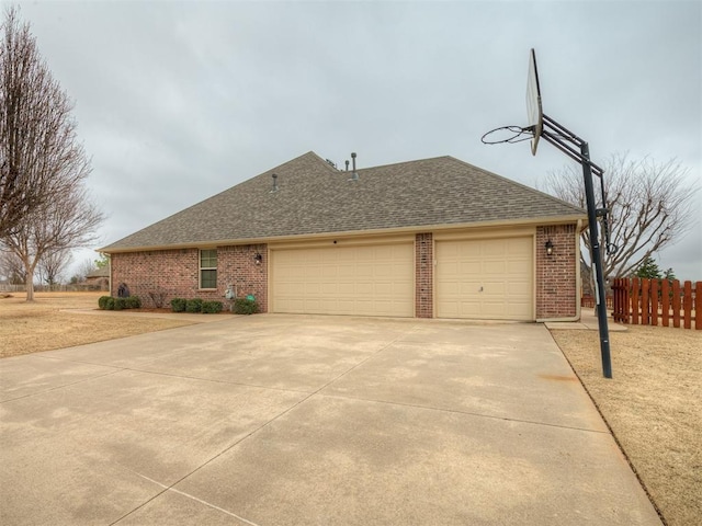 view of front facade featuring driveway, brick siding, a shingled roof, and fence