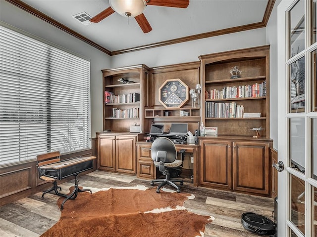 office space with light wood-type flooring, visible vents, a ceiling fan, and crown molding