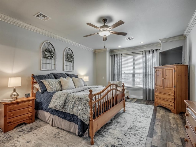 bedroom with ornamental molding, wood-type flooring, visible vents, and ceiling fan