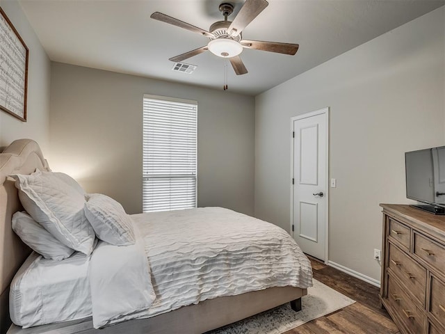 bedroom featuring ceiling fan, visible vents, dark wood finished floors, and baseboards