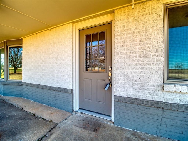 view of exterior entry featuring brick siding