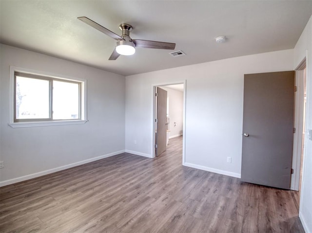 unfurnished bedroom with visible vents, baseboards, and wood finished floors