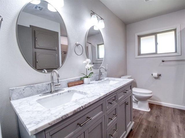 bathroom with visible vents, wood finished floors, a sink, and toilet