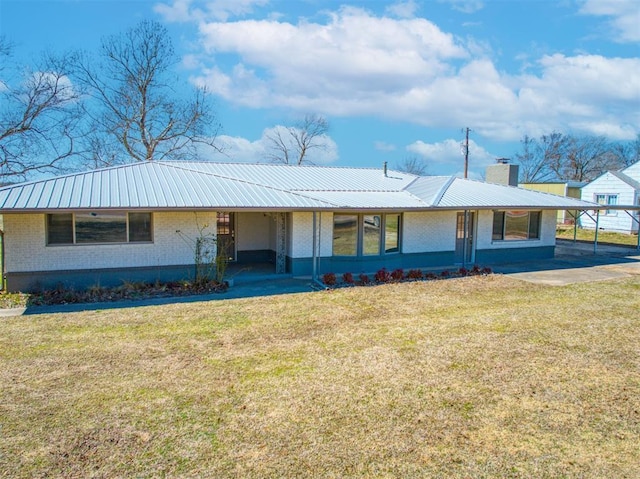 single story home featuring a front lawn, metal roof, brick siding, and a chimney