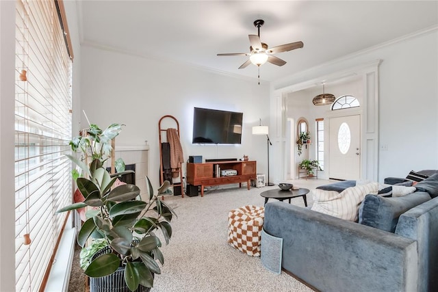 living room with ornamental molding, carpet flooring, and a ceiling fan