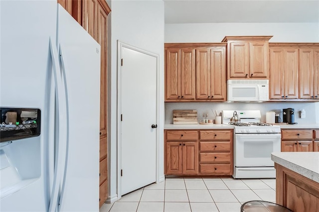 kitchen featuring light tile patterned floors, light countertops, and white appliances