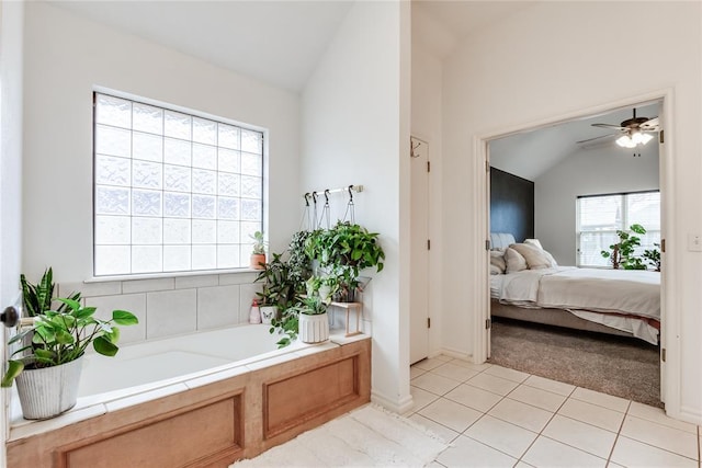 ensuite bathroom featuring lofted ceiling, ceiling fan, ensuite bath, and a garden tub