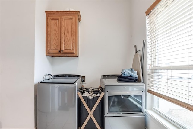 washroom featuring a wealth of natural light, independent washer and dryer, and cabinet space