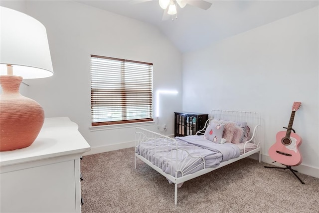 bedroom with light colored carpet, vaulted ceiling, baseboards, and ceiling fan