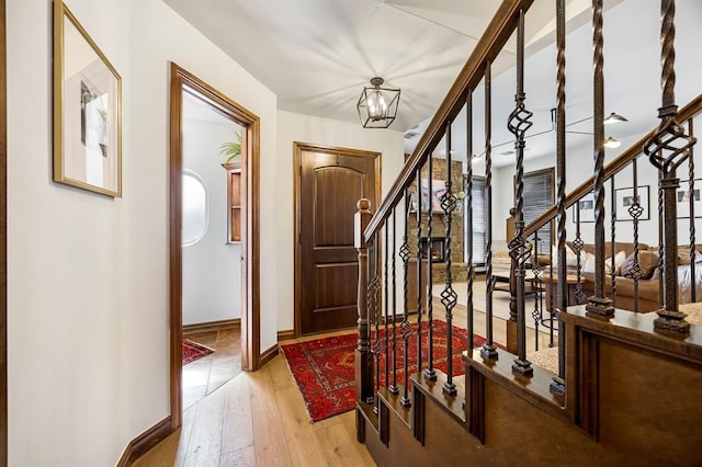 entrance foyer with stairway, a notable chandelier, baseboards, and wood-type flooring