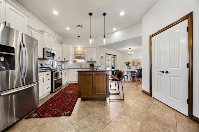 kitchen featuring tasteful backsplash, visible vents, a center island, white cabinets, and stainless steel appliances