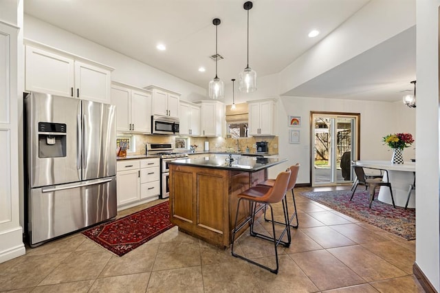 kitchen with visible vents, decorative backsplash, white cabinets, appliances with stainless steel finishes, and dark countertops