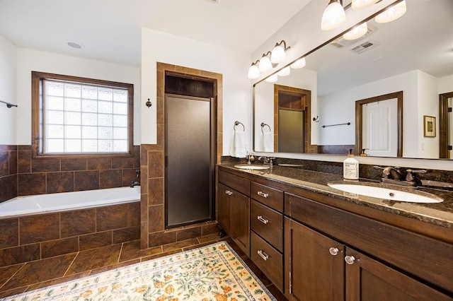 full bath with a shower stall, a garden tub, double vanity, and a sink