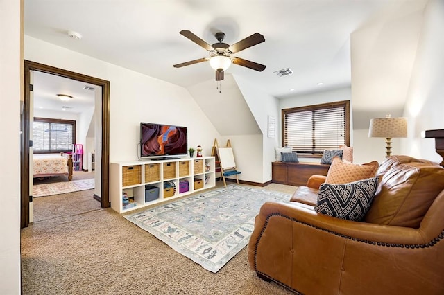 living room featuring baseboards, visible vents, carpet floors, lofted ceiling, and ceiling fan