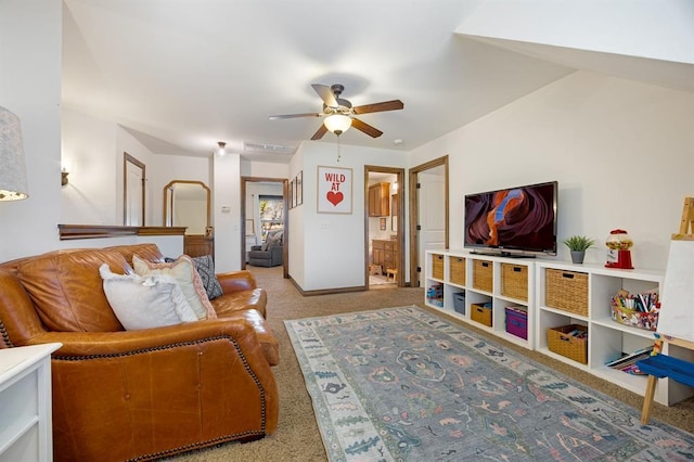 carpeted living area with visible vents, baseboards, and ceiling fan