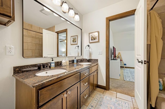 bathroom with double vanity, visible vents, baseboards, and a sink