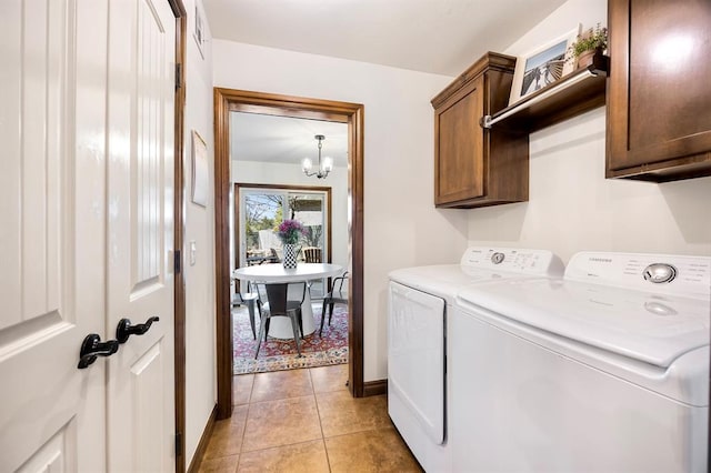 laundry room with baseboards, washer and clothes dryer, light tile patterned floors, an inviting chandelier, and cabinet space