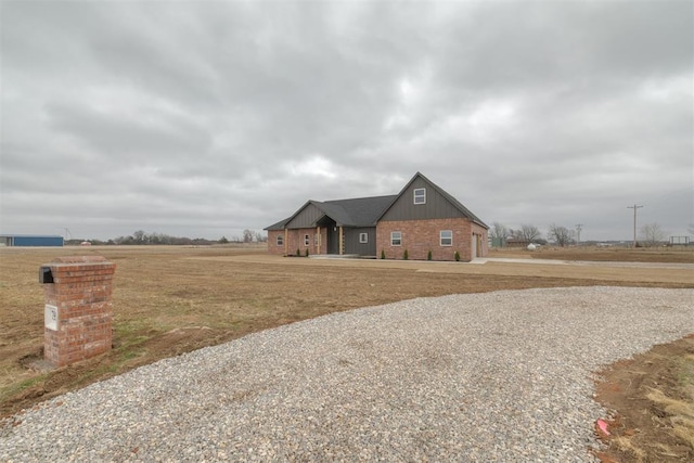 view of front of property featuring board and batten siding and brick siding