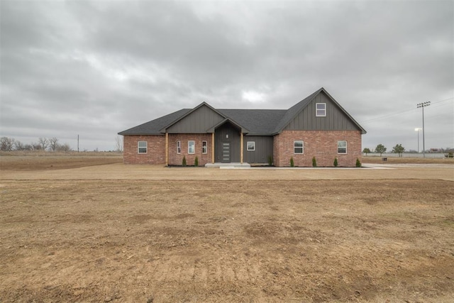 view of front of property featuring board and batten siding and brick siding