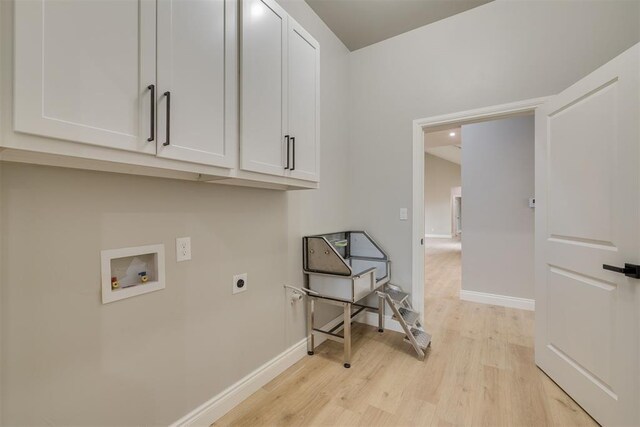 laundry area featuring hookup for a washing machine, light wood-style flooring, hookup for an electric dryer, baseboards, and cabinet space