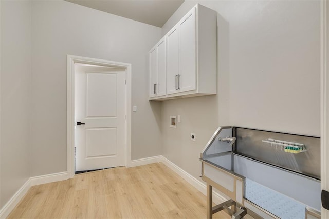 washroom featuring cabinet space, light wood finished floors, baseboards, washer hookup, and electric dryer hookup