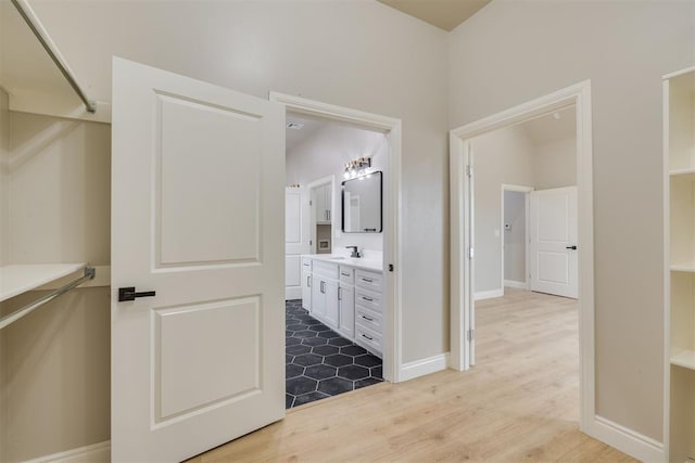 bathroom featuring wood finished floors, vanity, and baseboards