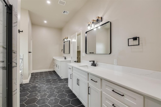 full bath featuring two vanities, visible vents, and a sink