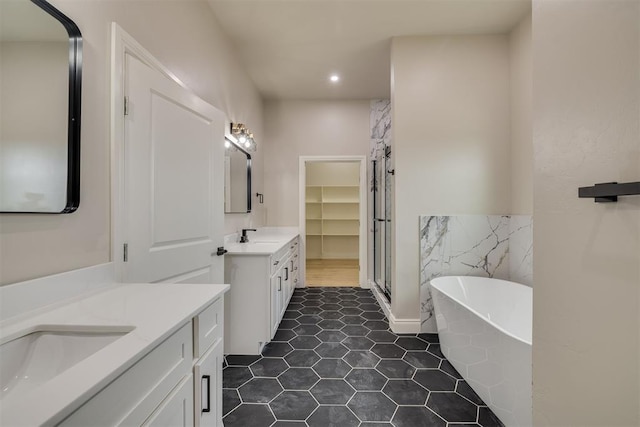 bathroom featuring a freestanding bath, a sink, two vanities, and a shower stall