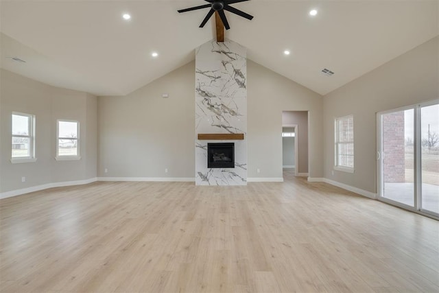 unfurnished living room with visible vents, a premium fireplace, high vaulted ceiling, light wood-type flooring, and beamed ceiling