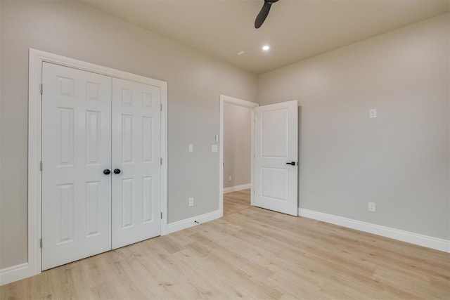 unfurnished bedroom with a ceiling fan, a closet, light wood-style flooring, and baseboards