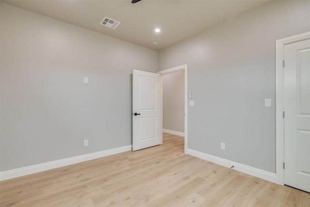 unfurnished room featuring light wood-style flooring, visible vents, baseboards, and recessed lighting