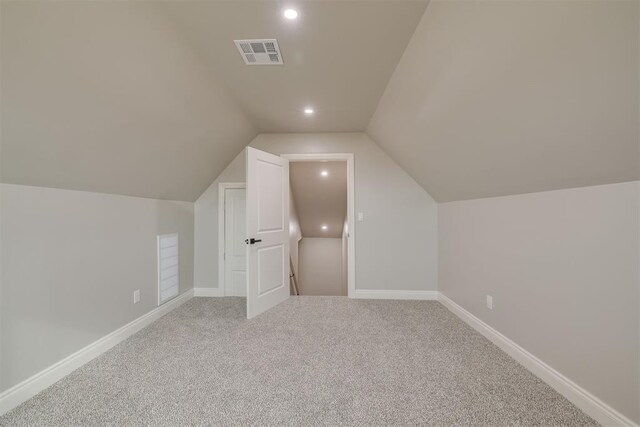 additional living space with lofted ceiling, recessed lighting, light colored carpet, visible vents, and baseboards