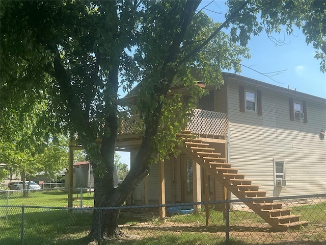 back of house featuring a fenced backyard, stairway, and a lawn