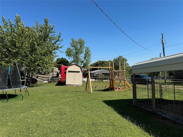 view of yard featuring a playground, an outdoor structure, fence, a storage unit, and a trampoline