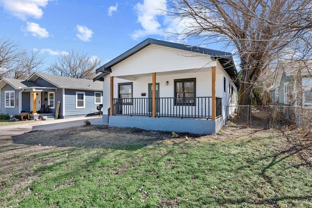 bungalow featuring a front lawn, fence, and a porch