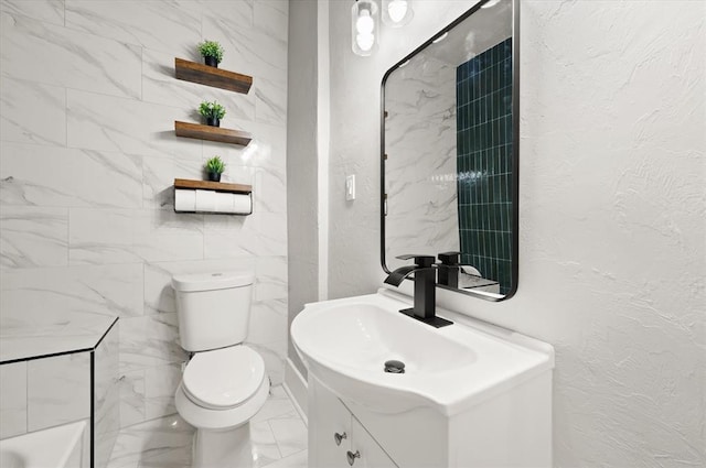 bathroom with a textured wall, marble finish floor, vanity, and toilet