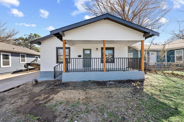 bungalow-style home featuring a porch and fence