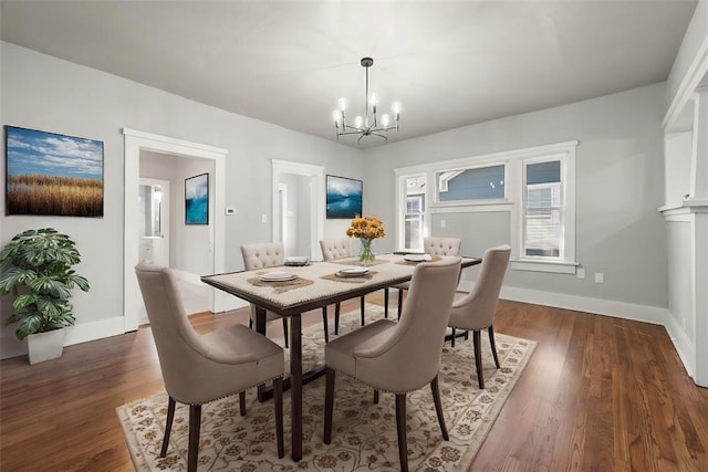 dining room featuring a chandelier, dark wood finished floors, and baseboards