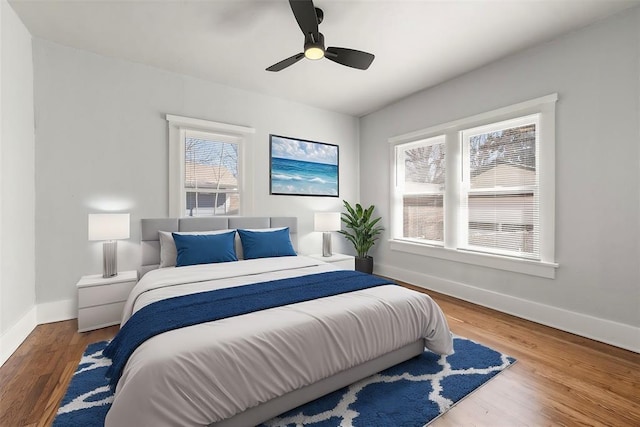 bedroom with a ceiling fan, baseboards, and wood finished floors