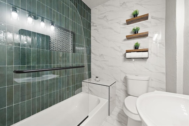 full bath with toilet, marble finish floor, tile walls, and a bath