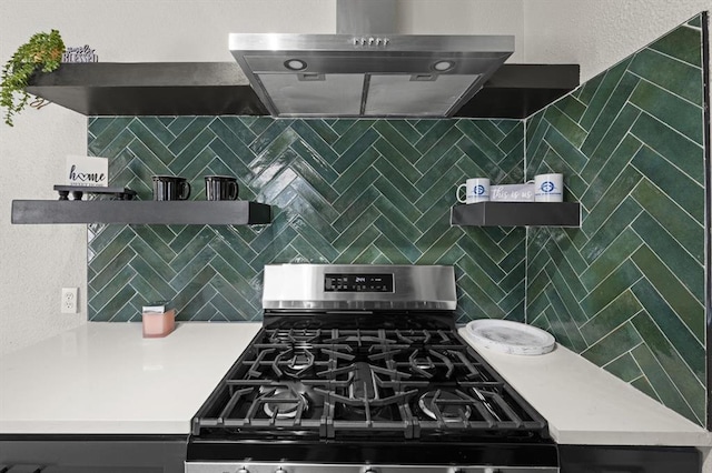 kitchen with open shelves, tasteful backsplash, light countertops, gas range, and wall chimney exhaust hood