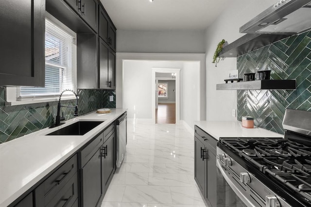 kitchen featuring appliances with stainless steel finishes, marble finish floor, light countertops, and a sink