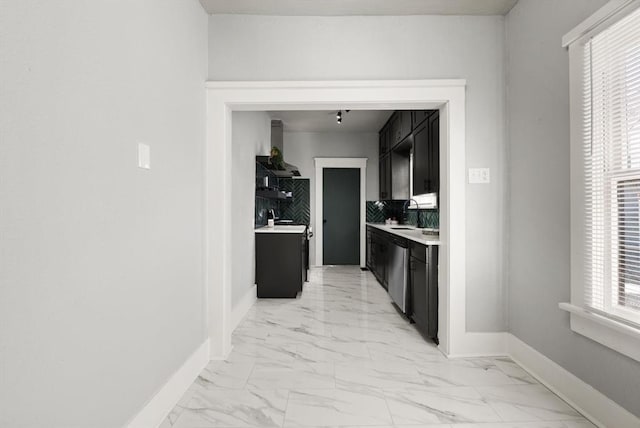 hallway featuring marble finish floor and baseboards