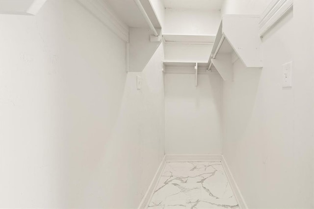 walk in closet with marble finish floor