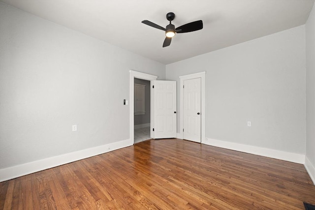 unfurnished room featuring a ceiling fan, baseboards, and wood finished floors